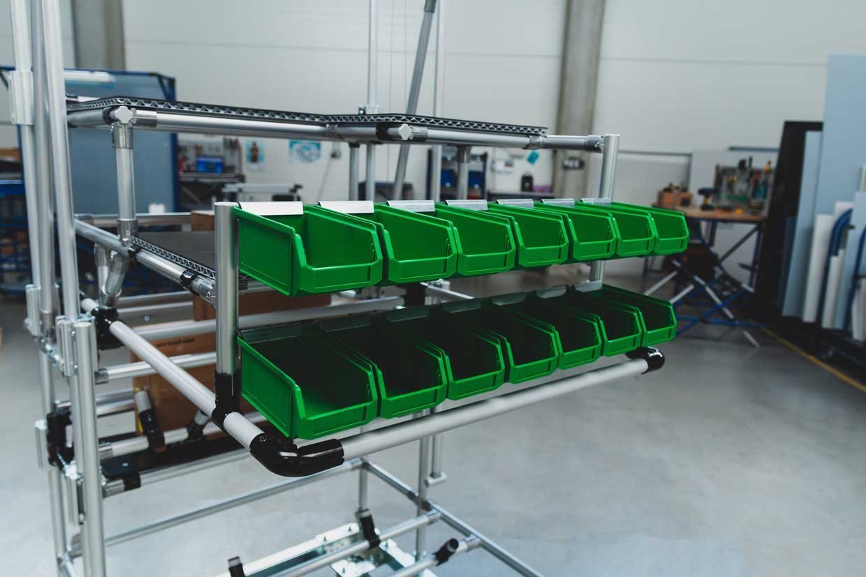 Zelené úložné boxy pro více úložného prostoru na montážní lince