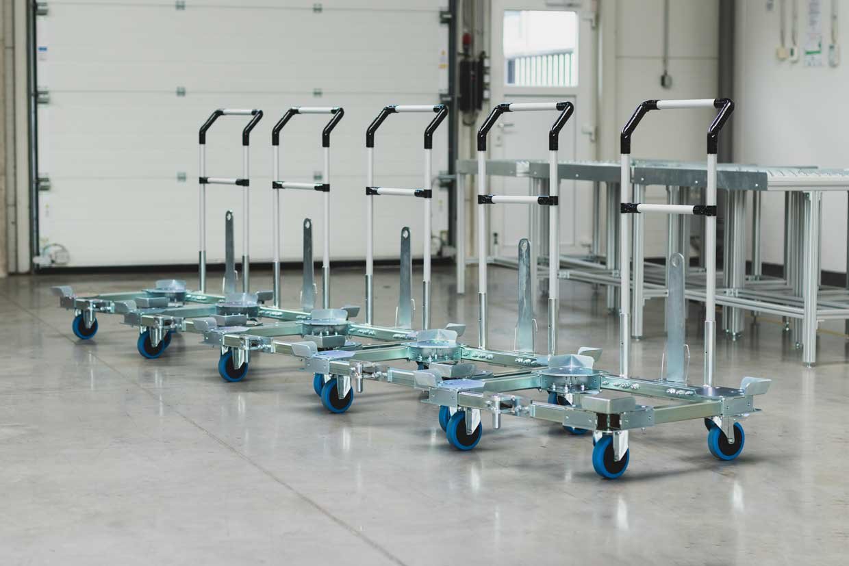5 identical transport trolleys with chassis frame made of square profiles and 4 wheels with blue tread each