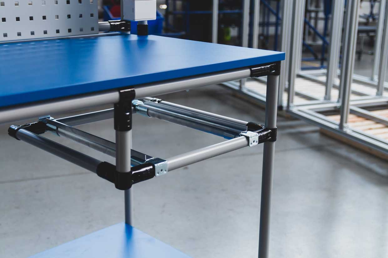 Individual industrial workstation with blue table top and storage space for a box