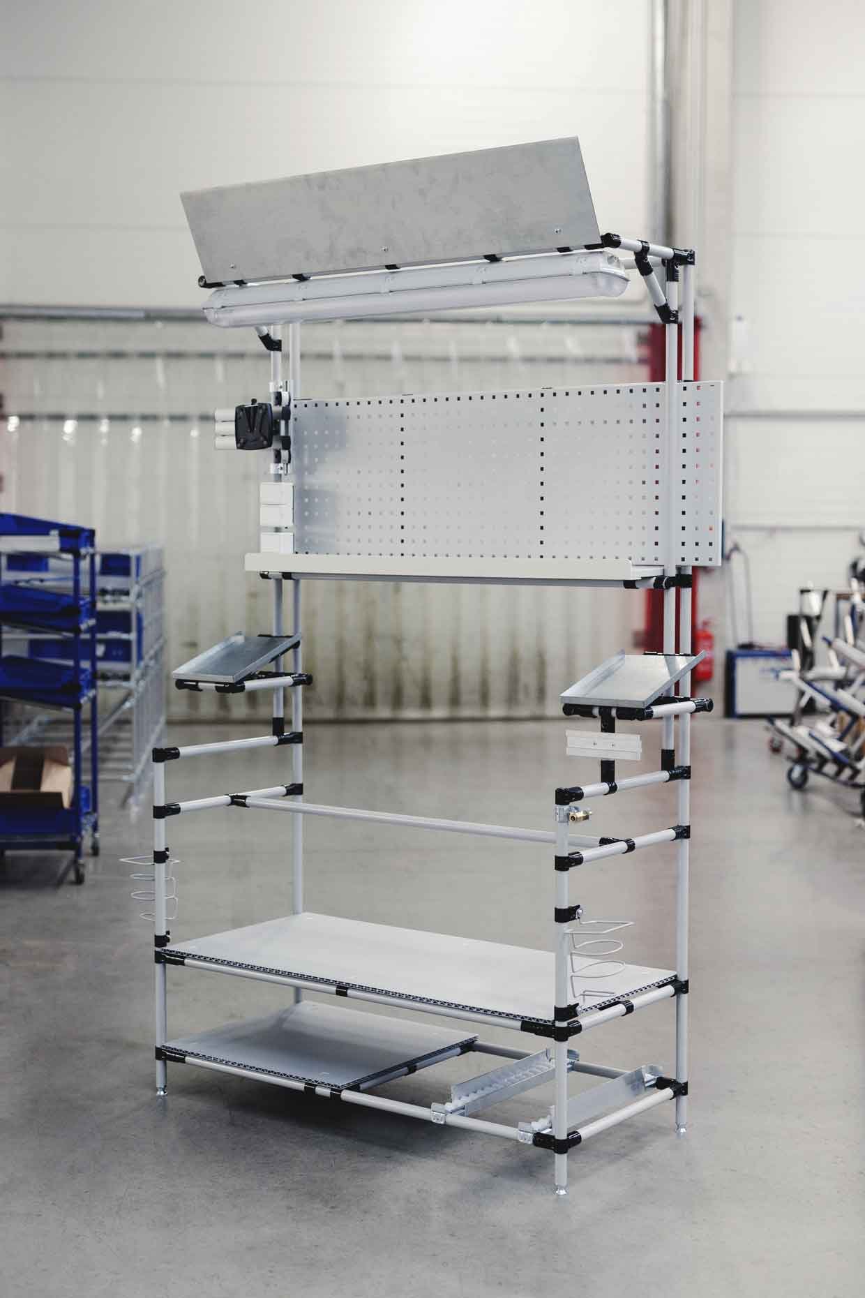 Assembly workstation made of round tubing with height-adjustable feet to compensate for unevenness