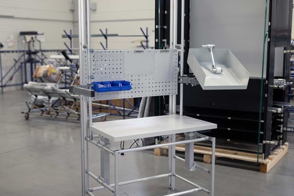 Assembly workstation made of aluminum pipe system with integrated lifting system for ergonomic height adjustment
