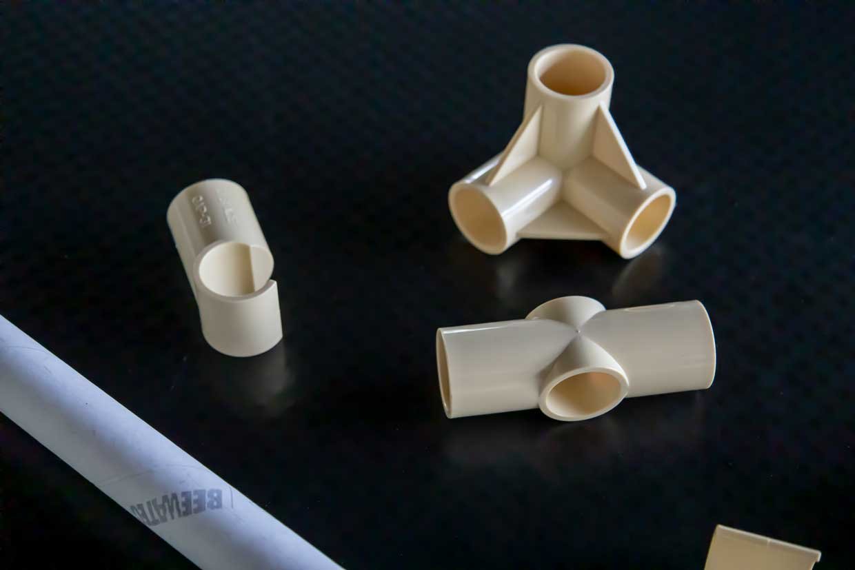 Různé typy plastových trubkových spojů v bílé barvě slonové kosti 