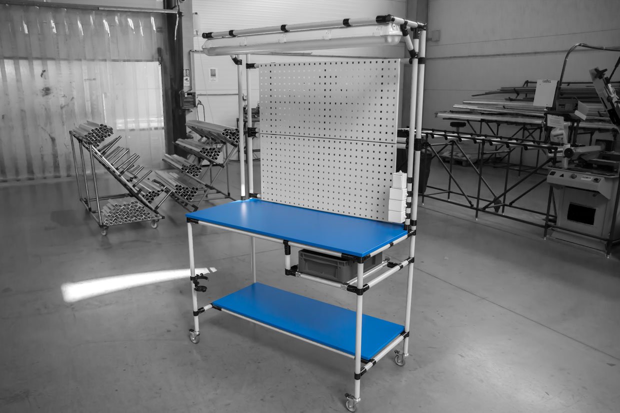 Assembly workstation made of steel round pipes with blue panels and a practical perforated plate as a back wall