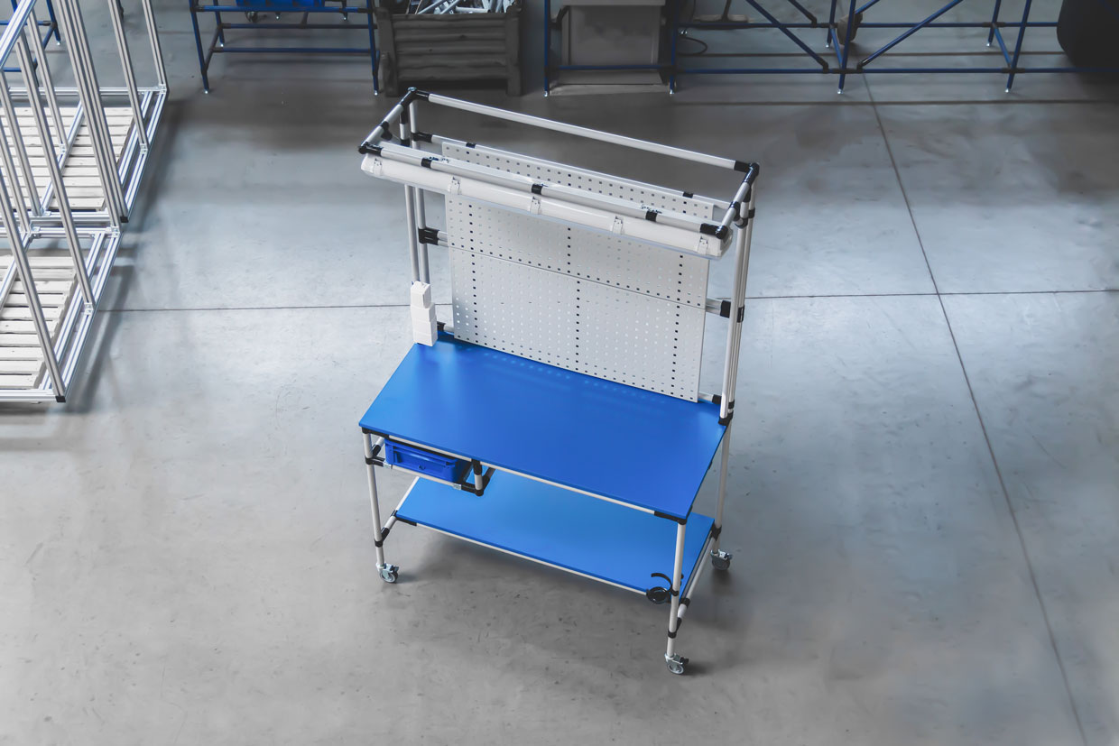 A workstation constructed by BeeWaTec from steel pipes with blue panels and various accessories.